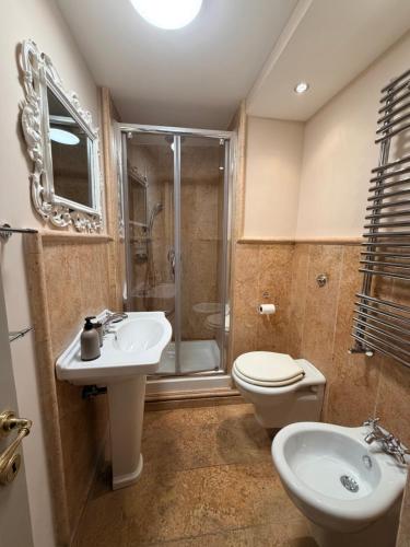 a bathroom with a sink and a toilet and a shower at L' Appartamento Experience in Tivoli