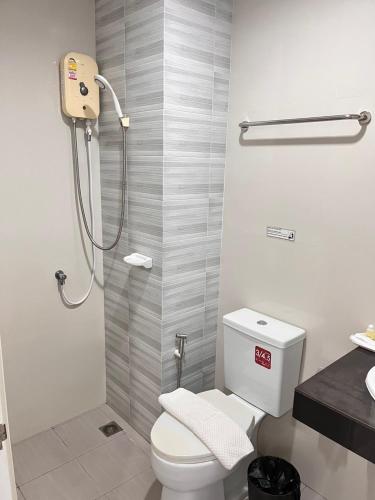 ein Badezimmer mit weißer Toilette und Dusche in der Unterkunft SC Residences in Surat Thani