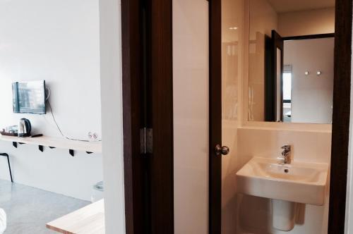 a bathroom with a sink and a mirror at A3 Living in Suratthani