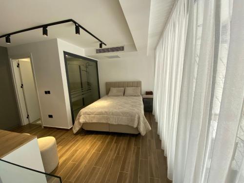 a bedroom with a bed and a white curtain at Loft One Bedroom with Shared Private Pool in Aglantzia