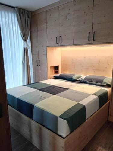 a large bed in a room with a window at BORMIO Apartment AL PRADAIS in Bormio