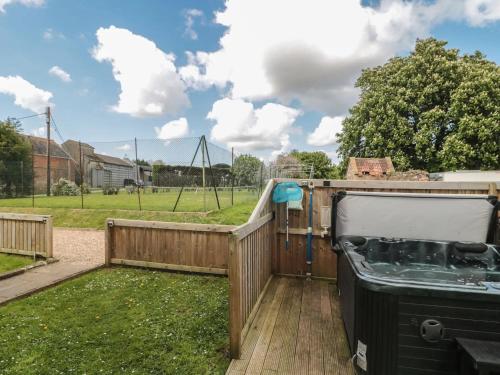 a backyard with a fence and a playground at Countryside Annexe, with hottub, sleeps up to 4 in Durston