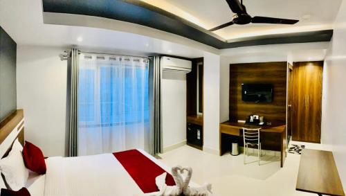 a bedroom with a red and white bed and a desk at Shanti Regency in Guwahati