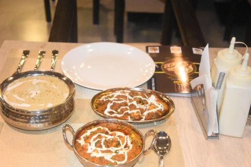 a table with two dishes of food on a table at Shanti Regency in Guwahati