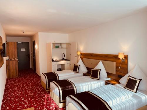 a hotel room with two beds and a red carpet at Hotel Luna in Offenbach