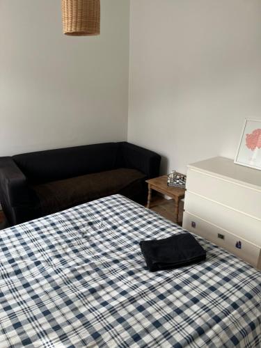 a bedroom with a bed with a black hat on it at Petite chambre in La Madeleine