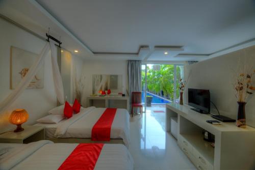 um quarto de hotel com duas camas e uma televisão em Angkor Sweet Night Hotel em Siem Reap