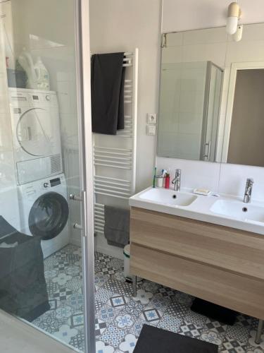 a bathroom with a sink and a washing machine at Petite chambre in La Madeleine