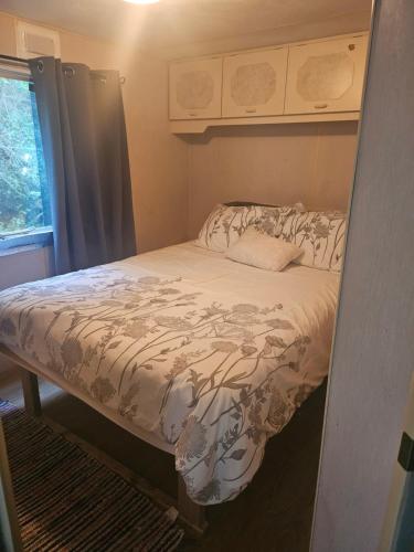 a small bed in a small room with a window at An Tigin in Cahersiveen