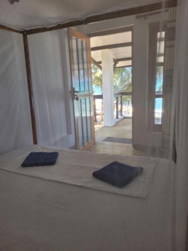 a bed in a room with two blue pillows on it at Galaxy Lounge in Arugam Bay