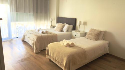a bedroom with two beds with towels on them at Casa Ponte do Mar in Sines