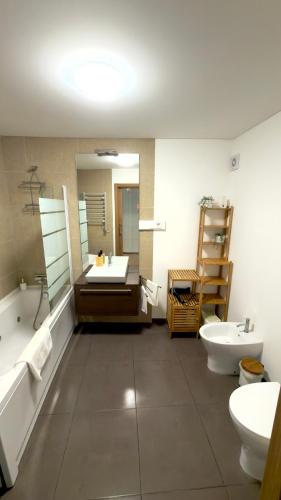 a bathroom with a tub and a sink and a mirror at Casa Ponte do Mar in Sines