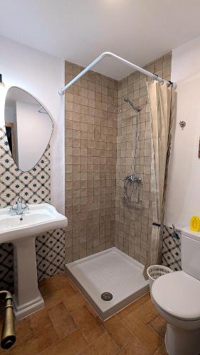 a bathroom with a shower and a sink and a toilet at casa rural Ribera del Hueznar in Constantina