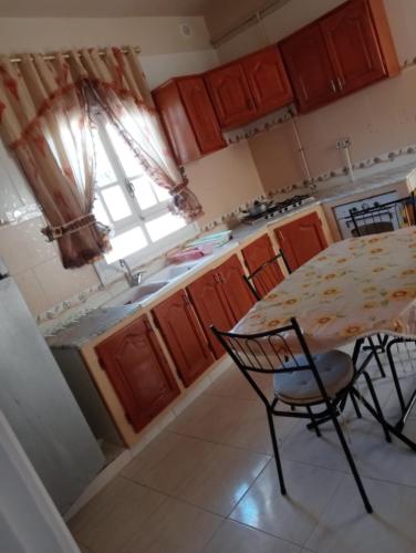 a kitchen with a table and a sink and a window at Maison au rez-de-chaussée à Mahdia rejiche in Mahdia