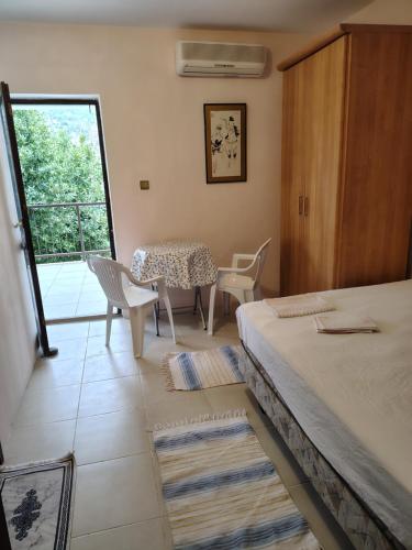 a room with a bed and a table and chairs at Guest house Ruzica in Sutomore