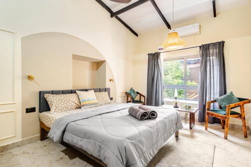 a bedroom with a bed and a window at Casa Century Anjuna in Anjuna
