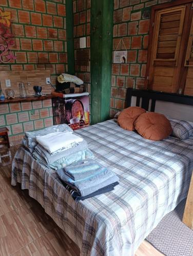 a bed with towels stacked on top of it at Chalés Crismel in Viçosa do Ceará