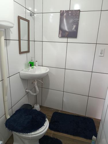 a bathroom with a toilet and a sink and a mirror at Chalés Crismel in Viçosa do Ceará