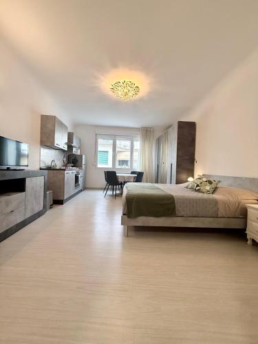 a large bedroom with a bed and a dining room at Loft moderno nel cuore del Centro Storico - spazioso & luminoso WiFi veloce- Tutto a piedi in Pordenone