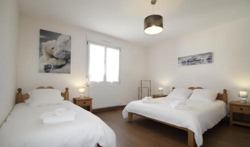 a bedroom with two beds and a window at LE CANT DE JUME in Gérardmer