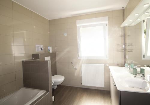 a white bathroom with a toilet and a sink at LE CANT DE JUME in Gérardmer
