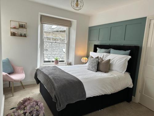 a bedroom with a large bed with a blue headboard at 2 bed period cottage sleeps 4 in central Crickhowell in Crickhowell