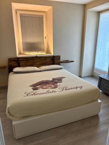 a large bed in a room with a window at La Piazzetta in Sondrio