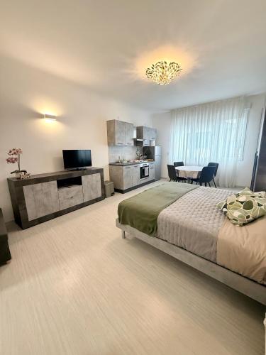 a bedroom with a bed and a kitchen and a table at Loft moderno nel cuore del Centro Storico - spazioso & luminoso WiFi veloce- Tutto a piedi in Pordenone