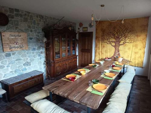 a long wooden table with bowls and plates on it at Agricampeggio Boschetto Gioioso in Barbiano