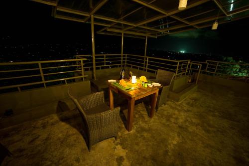 a table and chairs on a balcony at night at Range Kandy in Kandy