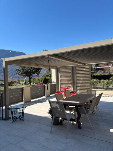 a patio with a table and chairs under a pavilion at La Piazzetta in Sondrio