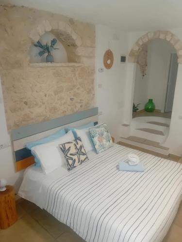 a bedroom with a bed with white sheets and pillows at CASA COTA in Mattinata