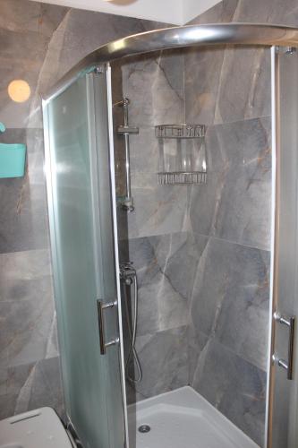 a shower with a glass door in a bathroom at Art.Villa.Nike in Koinyra