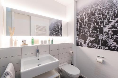 a white bathroom with a sink and a toilet at Motorworld Inn Hotel Böblingen in Böblingen