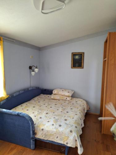 a bedroom with a blue bed in a room at Po Beržu in Molėtai