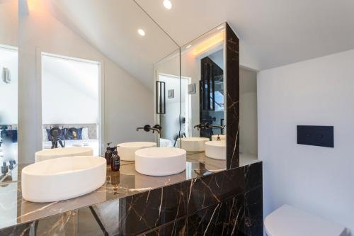 a bathroom with four sinks and a large mirror at Rossio individual Suites Lisbon in Lisbon