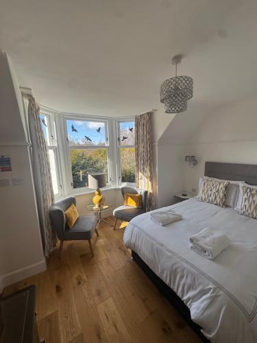 a bedroom with a large white bed and windows at Crannach House bed and breakfast and self catering apartments in Ballater