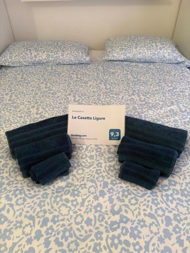 a bed with black pillows on it with a box on it at La Casetta Ligure in Borghetto Santo Spirito
