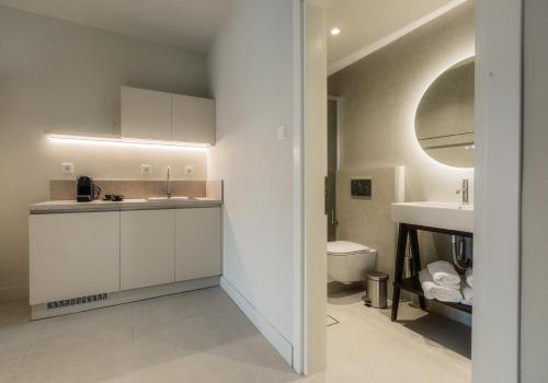 a white bathroom with a sink and a toilet at Nest Limeni in Limeni
