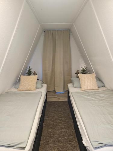two twin beds in a room with a window at Finnhaus 1 Strandbad Adria in Kleutsch