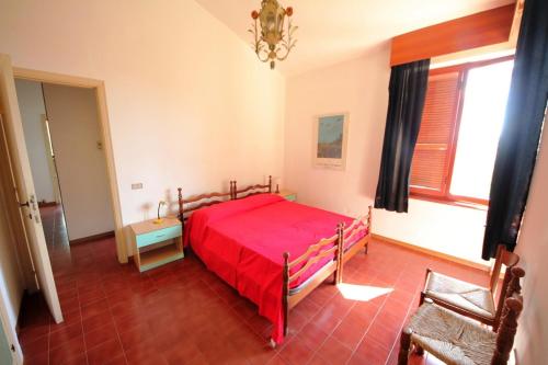 a bedroom with a red bed and a chair at Villa Pentalocale cod 168- Taunus Vacanze in Numana