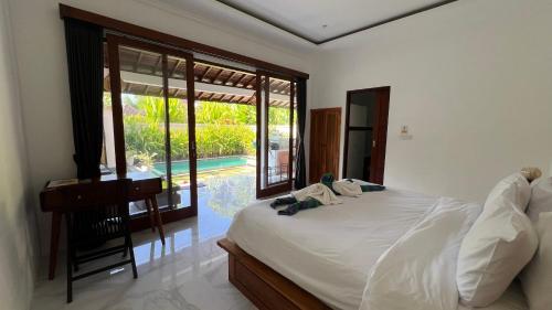 a bedroom with a bed and a desk and a pool at Ubud jungle House behind bintang supermarket ubud in Ubud