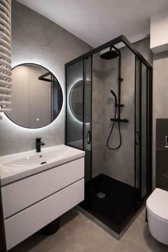 a bathroom with a sink and a shower at Studio Odrodzenia 5 Centrum Lubina in Lubin