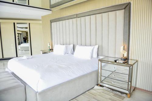 a bedroom with a large white bed and a glass table at Nandoni Waterfront Resort in Thohoyandou