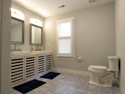 a bathroom with a toilet and a sink and a window at The Sunrise On Sunset in West Cape May