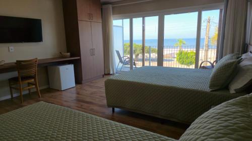 a bedroom with a bed and a view of the ocean at Pousada Trapiche in Pelotas