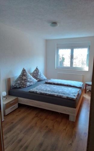 a bedroom with a bed and a window at Weitblick am Hankehübel in Hohnstein