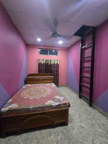 a bedroom with a bed in a room with pink walls at A Homestay in Amingaon