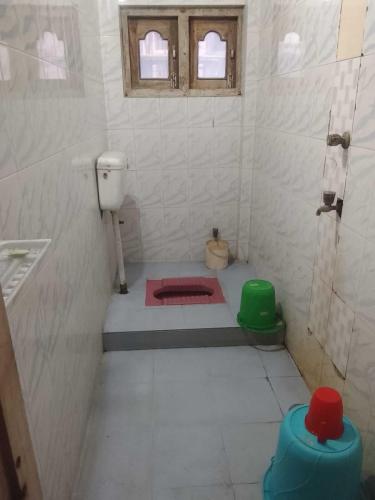 a white bathroom with a toilet and a sink at A Homestay in Amingaon