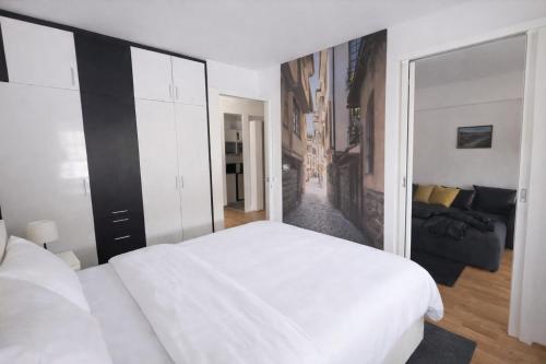 a bedroom with a white bed and a living room at Petar Apartment-City Center, Ohrid in Ohrid